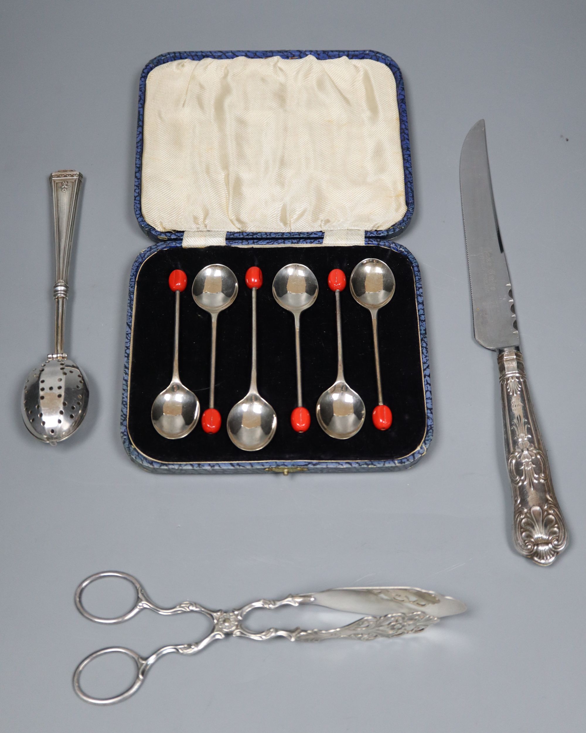 An 830s pastry tongs, a knife, a cased set of six bean end coffee spoons and an infuser.